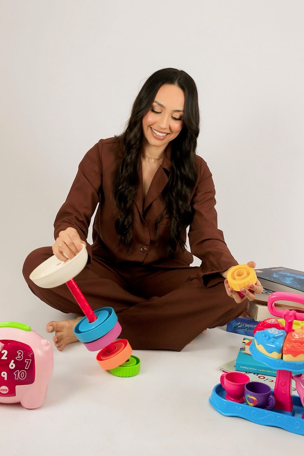Anna Laura com um brinquedo de encaixe e materiais lúdicos infantis