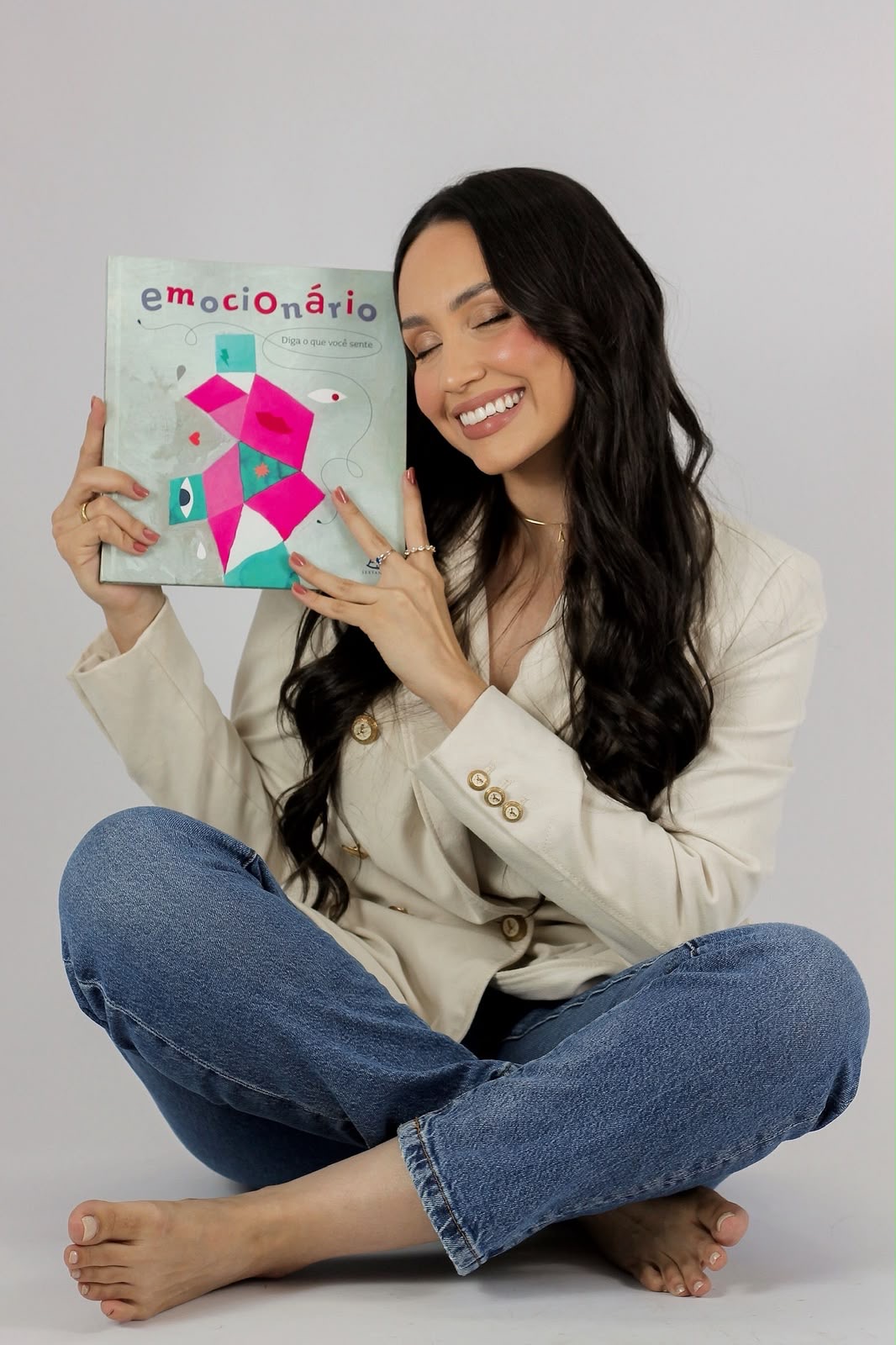 Anna Laura segurando o livro Emocionário, um recurso para conversar sobre sentimentos